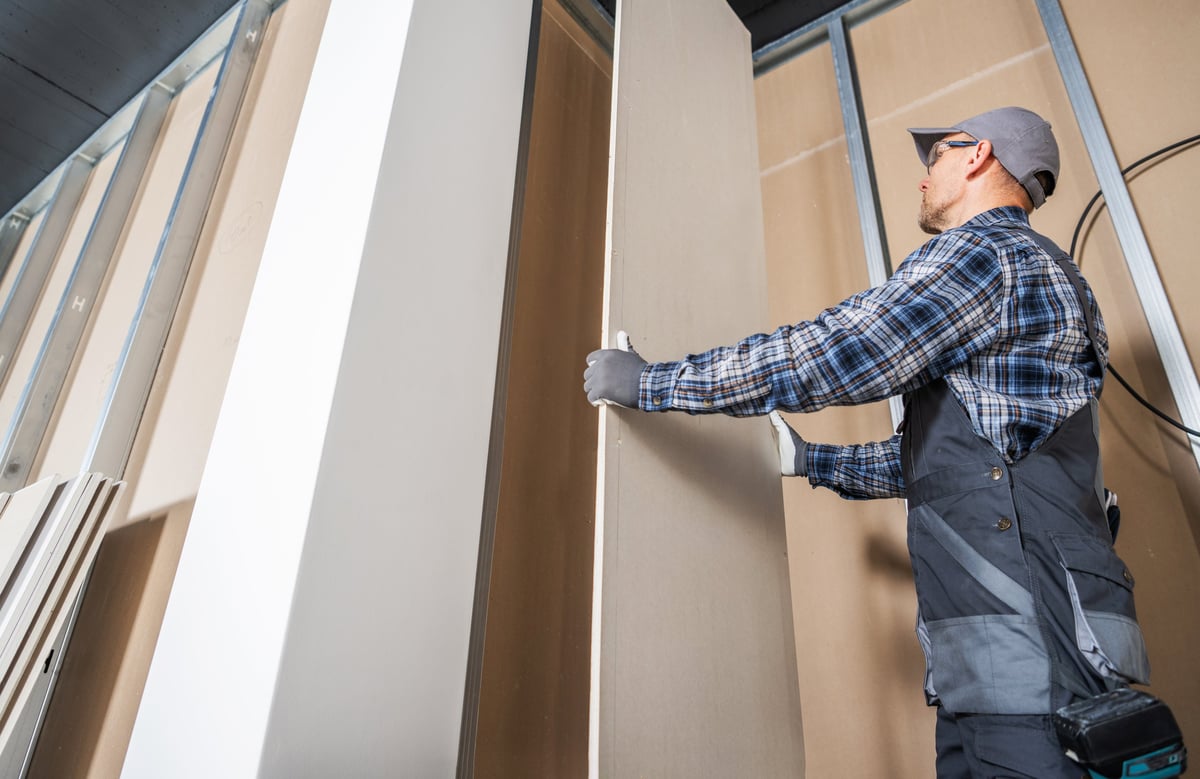Handwerker montiert eine Trockenbauwand im Innenausbau eines Neubaus