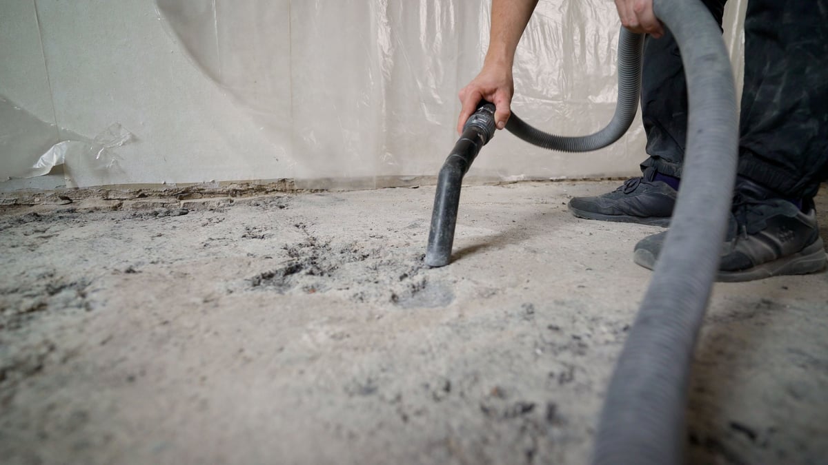 Fachkraft reinigt einen Boden mit einem Industriestaubsauger nach Bauarbeiten