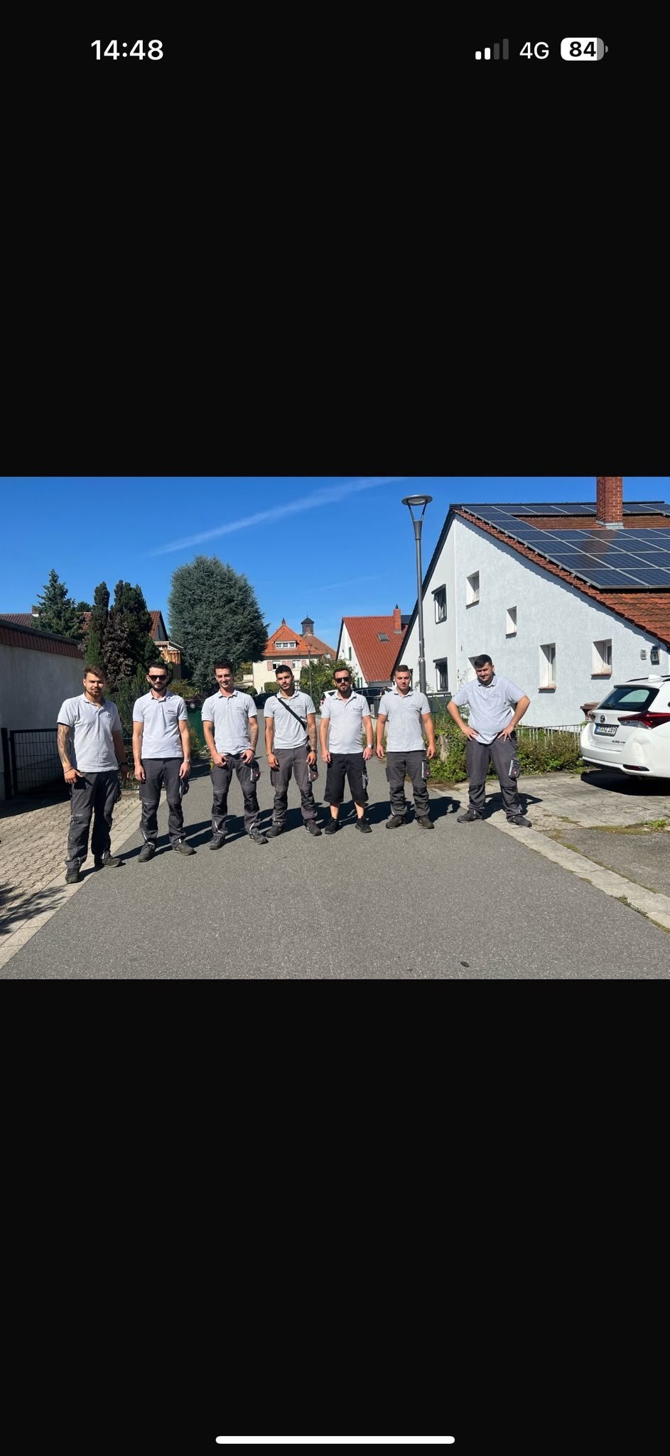 Das Melix-Team – acht Mitarbeiter in weißen T-Shirts stehen in einer Reihe auf einer Anwohnerstraße